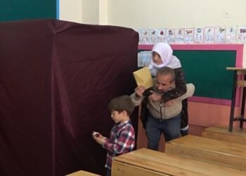 ناخب تركي يحمل والدته المسنة على ظهره متوجهًا لصناديق الاقتراع في الجولة الثانية